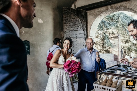 At Sorrivoli Castle, Cesena, Italy, after the celebration, the bride's grandfather joyfully tastes gelato given to guests.