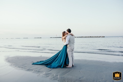 At Becky Bay Venue, Bellaria, Italy, the spouses share an intimate scene on a tidal sandbar at sunset before the party begins.