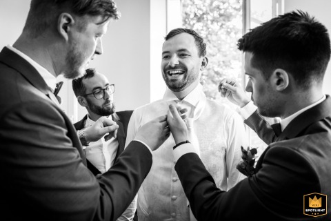 A WPJA wedding photo: Men's preparations at Château de Millery-Autun, showing the groom with others laughing in a black and white image.