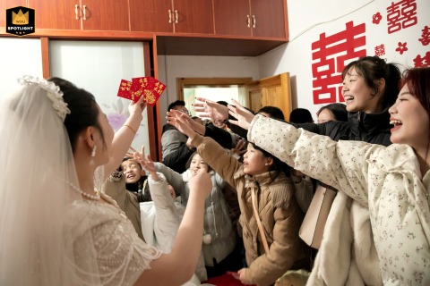 During the Ji'an wedding customs, everyone scrambles for red envelopes in the bride's hand, creating a festive and lively scene.