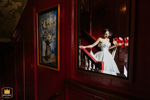 At The Union Club Soho, England, the bride descends a staircase in the tiny member's club, reflected in a large indoor mirror.
