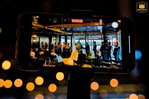 At District Winery, Washington DC, a detail shot captures a phone camera in video mode, recording the first kiss.