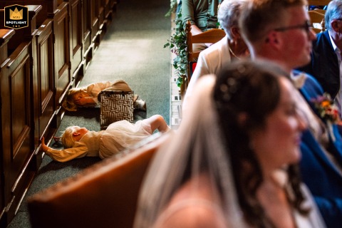 A WPJA wedding photo: In a church ceremony in Zuid Holland, Netherlands, young bridesmaids are seen laying on the floor.