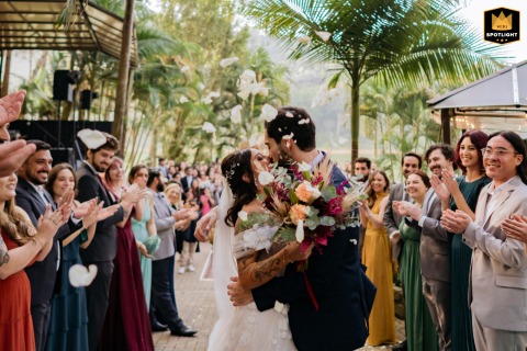 A WPJA wedding photo: During a São Paulo ceremony, a kissing couple is showered with flower petals, surrounded by guests.