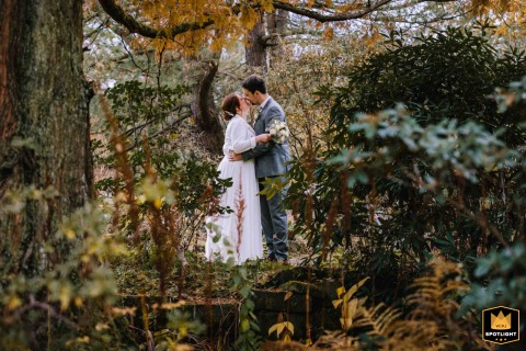 At Haus Herbede, Bochum, Ruhrgebiet, a couple poses for their autumn portrait session, beautifully framed by foliage.