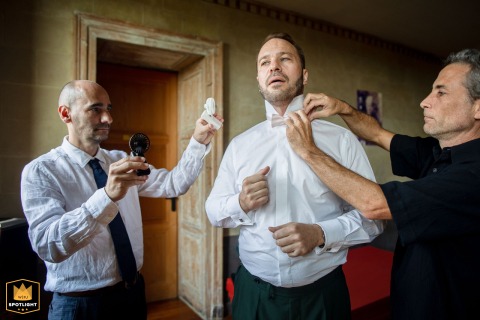 At Château de Fortis, France, the best man uses small handheld fans to provide fresh air, a thoughtful gesture captured by a WPJA photographer.