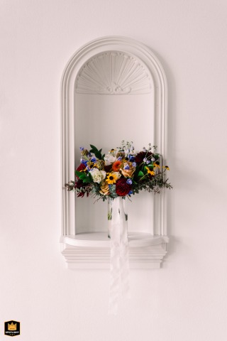 A minimalist detail shot at an Airbnb in Blaine, WA: a wedding bouquet perfectly placed within an old telephone nook in white walls.