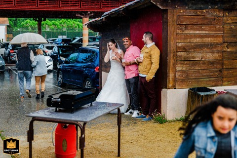 Bride and guests with umbrellas arrive at Basque Country wedding reception, walking through rain and puddles, but the wedding must go on.