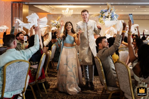 Bride and groom joyfully enter the room at Shendish Manor for their wedding breakfast, greeted by applauding family and friends.
