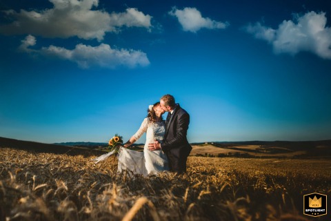 In Crete Senesi, Tuscany, the couple’s kiss stands out against a dramatic blue sky filled with sweeping clouds, creating a striking and romantic portrait amid the region’s breathtaking landscapes.