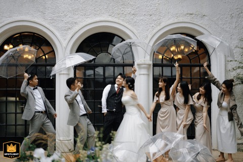 In front of an old Western-style house on Panyu Road, Shanghai, China, the couple and their friends gather amid gentle rain, creating a lively and romantic wedding scene against the backdrop of white-walled architecture.