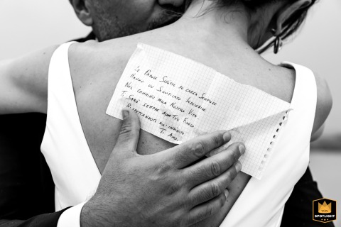 At Saline di Cervia in Italy, a black and white detail shot captures the groom's sweet love declaration, handwritten on a note, during their intimate wedding.