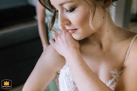 In Schalksmühle, Sauerland, Germany, the bride pauses during her getting ready moments to gently touch her shoulder in a reflective, intimate posture, capturing anticipation and emotion before the ceremony.