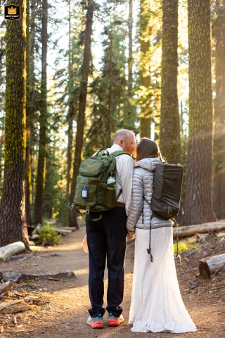 After hiking over 10 miles, a couple pauses in the late afternoon sun at Crater Lake National Park, Oregon. The image captures their adventurous wedding day.
