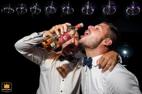 In Santa Fe, Argentina, the groom gives whiskey to his best man. The candid moment captures a shared toast and camaraderie at the wedding.