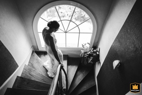 At the groom's parents' home in France, a bride walks down the stairs for her first look. She is preparing to see her groom for the first time, a beautiful and emotional scene.