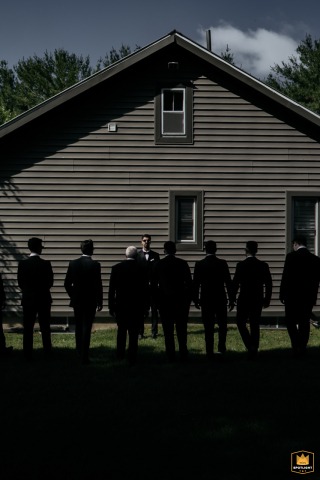 In Toronto, a groom is captured in a portrait with his groomsmen. The groom is bathed in sunlight while his groomsmen are silhouetted, creating a unique and bold composition.