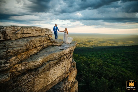 A couple takes wedding photos on a mountaintop in the Hudson Valley. Despite the ominous clouds, their happy photo session is captured against the dramatic, natural backdrop.