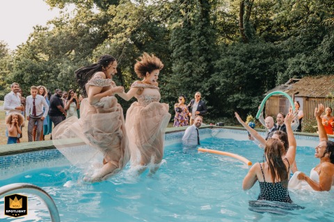 At Glansevin Mansion, bridesmaids leap into the pool hand in hand. The joyful and playful moment, met with cheers and laughter, captures the excitement of the wedding party.