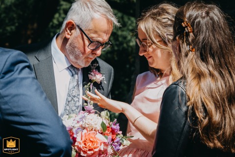 At Cathays Cemetery Chapel in Cardiff, a bride shares a quiet moment with her father. She shows him her new wedding ring, a beautiful and tender gesture between them.