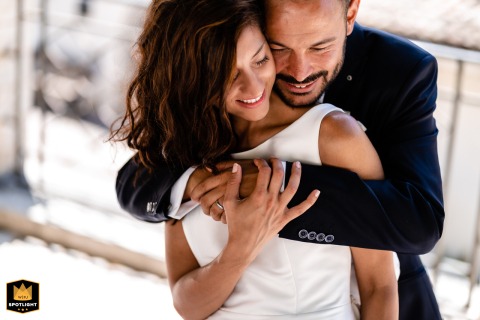 A portrait of the bride and groom is captured in Pettorano Sul Gizio, Italy. He tenderly embraces her from behind, showcasing their affection in the beautiful Italian setting.