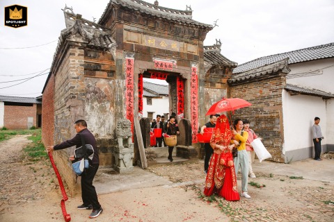A bride walks with reverence through an ancestral hall in Xunwu County, China. This quiet, traditional wedding custom takes place just before she leaves for her new home.