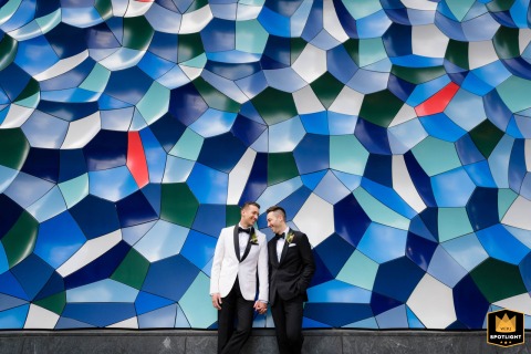At Willis Tower in Chicago, the groom poses for a striking wedding portrait beside a downtown geometric art installation. The bold urban lines and dramatic setting create a modern, memorable image capturing city energy and wedding excitement.