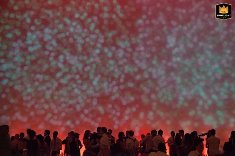 Guests dance in silhouette at the de Young Museum with a vibrant red light washing over the scene. The unique atmosphere and dynamic lighting create a high-energy moment on the dance floor.