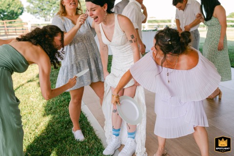 Wedding day laughter: a bride's joyous moment with her bridesmaids Bride laughs lifting her dress as bridesmaids fan her legs and lift her hair at a North Georgia private home.