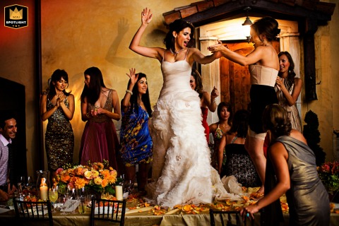 Sonoma Bliss: A Bride's Joyful Dance on Her Wedding Table Bride dances on a table at a wedding reception in Sonoma, California.