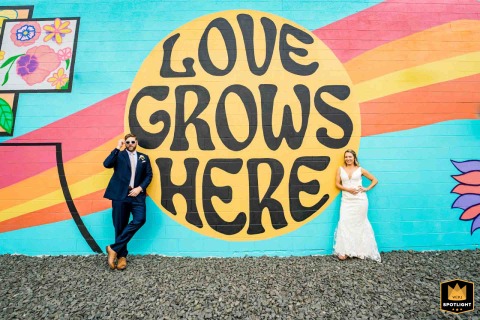 Vibrant Denver Wedding Portrait: Couple Poses with Mural at Mountain Crust Pizza Wedding couple poses with vibrant mural at Mountain Crust Pizza in Denver, CO.