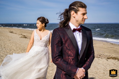 Long Island Love: A Beachside First Look with Waves in the Background Bride and groom stand on a Long Island, NY beach before their first look, with waves in the background.