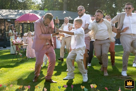 Groom with Bottle Runs from Guests at a Cocktail Wedding in Lille, France Groom with a bottle runs away from guests in Lille, Nord, France, at a cocktail wedding.