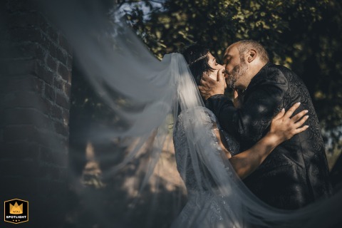 Ethereal Kiss at Podere Maison with Her Veil Sweeping Out of Frame Bride and groom kiss at Podere Maison with her veil sweeping out of the frame.