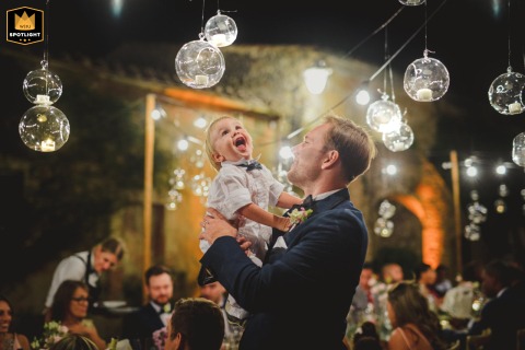 Whimsical Tuscany Wedding: A Young Boy's Wonder at Hanging Glass Balls A whimsical wedding at Villa Catignano, Tuscany. A young boy stares at hanging glass balls.