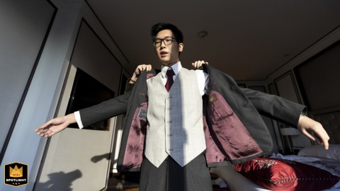 Pre-ceremony Prep: Groom Getting Ready with a Helper at the Plaza Athenee Bangkok A wedding photojournalist captures a low-angle shot of the groom getting into his jacket with a helper behind him at the Plaza Athenee in Bangkok.