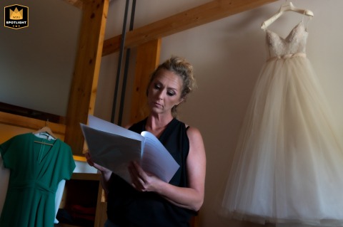 In A Moment Of Quiet, The Maid Of Honor Rehearses Her Speech Preparing for a wedding, a maid of honor in Trento, Italy, rehearses her speech while framed between her dress and the bride's gown.