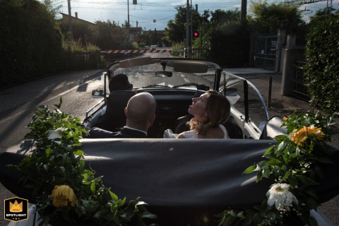 Anticipation and First Raindrops: A Bride's Moment in Mantova, Italy, Awaiting Fate A wedding photojournalist captures a bride in Mantova, Italy, checking the sky as the first raindrops fall on the glass at Villa Schiarino.