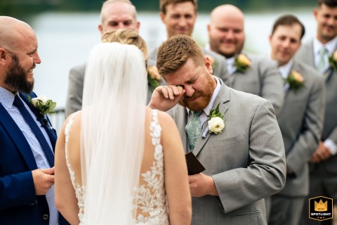 Groom Said His Vows, Wiping Tears, on a Beautiful Day at The Lake House The Lake House Inn, Philadelphia — A wedding photojournalist captures a groom overcome with emotion as he wipes away tears while saying his vows during an outdoor ceremony.