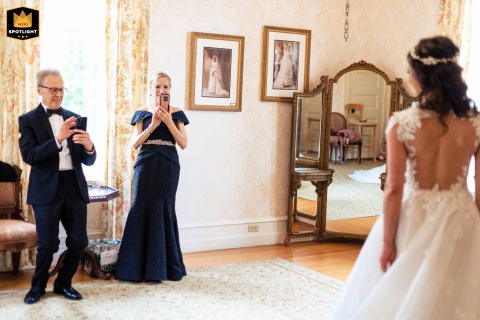 Beaming With Pride: A First Look with the Bride's Parents at Cairnwood Estate Philadelphia, Pa. — A wedding photojournalist captures a heartwarming first look at the Cairnwood Estate as the bride's parents beam with pride upon seeing her in her wedding dress.