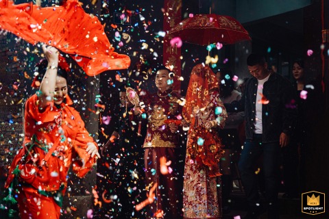 Fujian Wedding Fireworks: A Celebratory Departure of the Newlywed Couple A documentary photograph captures a celebratory moment as a newlywed couple leaves their home in Fujian, China. The image shows the bride and groom departing while fireworks are set off throughout the venue.