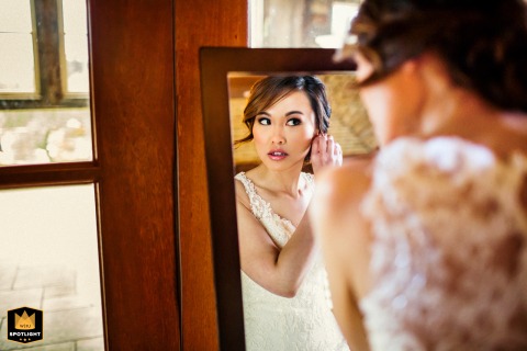 Bride Puts On Final Touch at Regale Winery in Los Gatos Bride in white dress at Regale Winery in Los Gatos, California, putting on an earring.