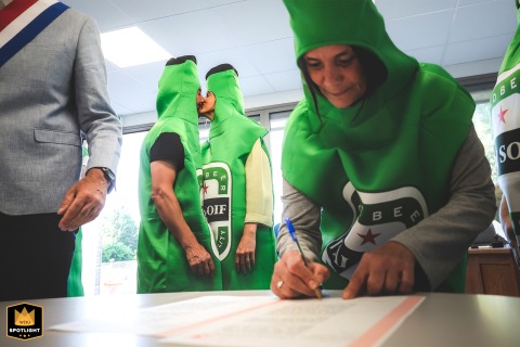 Heineken Bride and Groom Get Married in a Town Hall A documentary photograph captures a humorous moment during a civil ceremony at the Conne de Labarde town hall in France. The bride, groom, and a witness are dressed as Heineken beer bottles.