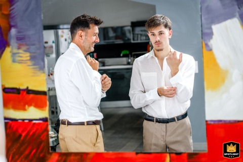 Tender Reflections: A Groom and Son Prepare for a Wedding Day A wedding photographer captures a tender moment in a private home. The image shows a groom getting ready with his son, their reflections visible in a mirror as they prepare for the ceremony.