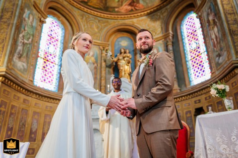 In Sacred Silence, A Shared Grace in Holy Union In the Notre Dame de Lafrançaise church, a wedding photographer captures a solemn moment. The photo shows the newlyweds during their religious ceremony, a moment of shared grace and emotion.