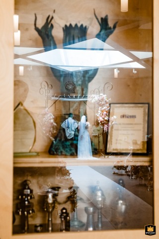 An Unconventional London Wedding Ceremony: Framed Through a Cupboard Door In London, a wedding photographer captures a unique perspective on a wedding ceremony. The image provides an intimate and unconventional glimpse of the moment, framed through a partially open cupboard door.