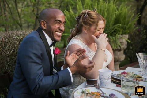 Radiant Bride And Groom Laughing During Wedding Toasts At Aska Farms Celebration Happy couple at Aska Farms, Blue Ridge, GA, sharing a laugh during wedding toasts at their table.