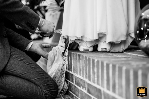 Timeless Black And White Moment: Groom Cuts Bride’s Dress At Château De Montalieu A black and white photo of the groom cutting a piece of the bride's wedding dress at Château de Montalieu.