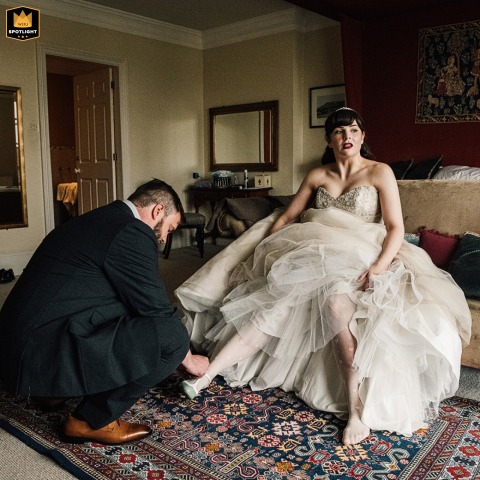 Groom Kneels To Help Bride With Wedding Shoes At Swinton Estate Elopement Swinton Estate elopement: The groom kneels to help his bride put on her wedding shoes during preparation.