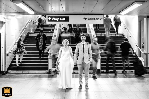 Couple Embraces Amidst Brixton Tube Station’s Bustle And Vibrant London City Life Couple stands intimately in Brixton Tube Station, a blur of commuters and London's vibrant life surrounding them.